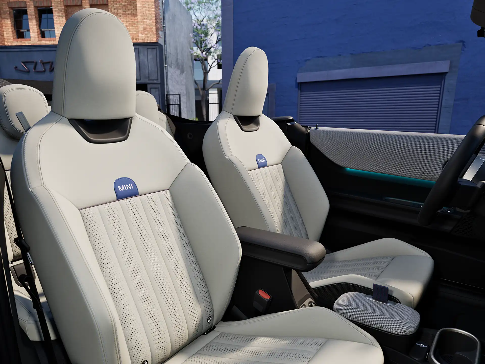Interior perspective of the MINI Cooper Convertible is showing the dashboard, steering wheel, round display and back of the frontseats.